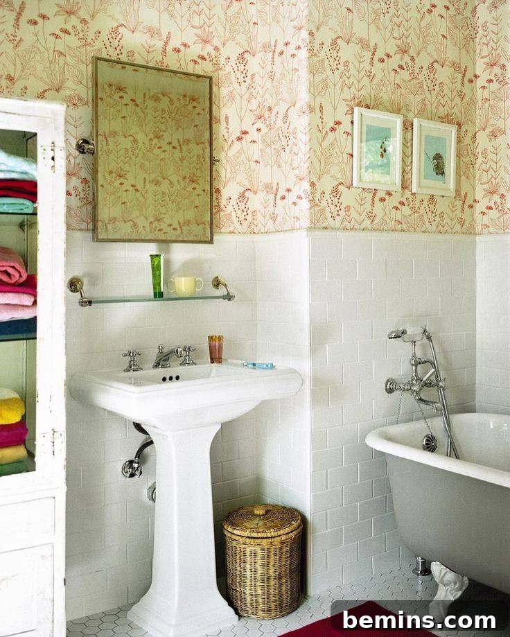 Tiled wainscoting in white with orange wallpaper in small bathroom