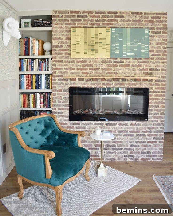Brick wall behind blue chair, with built-in electric fireplace