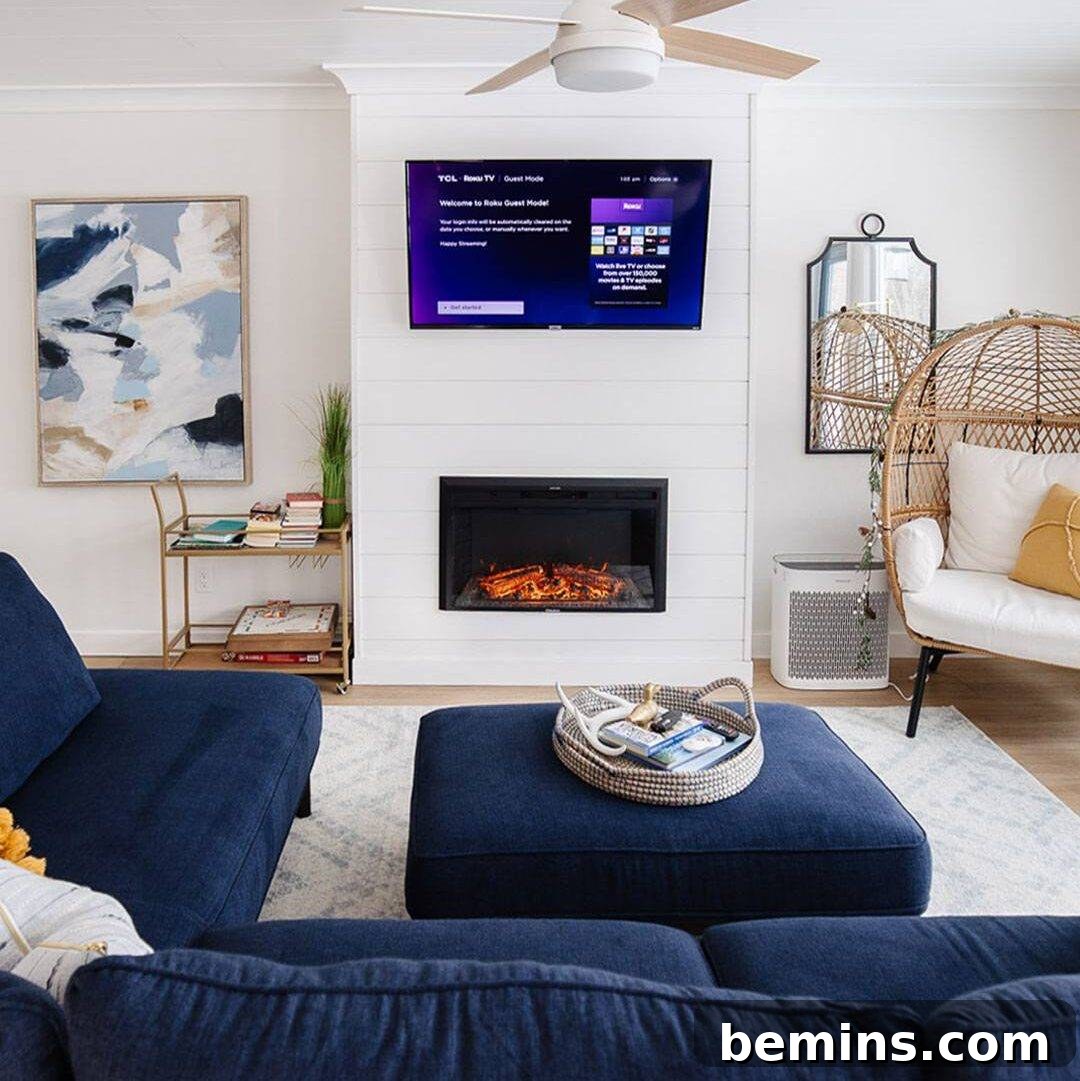White wall with shiplap in living room. Tv mounted against the wall with built-in electric fireplace.
