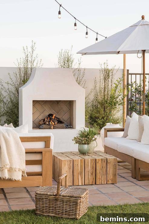 Off-white stucco fireplace in an outdoor patio with white patio chairs, creating an outdoor oasis