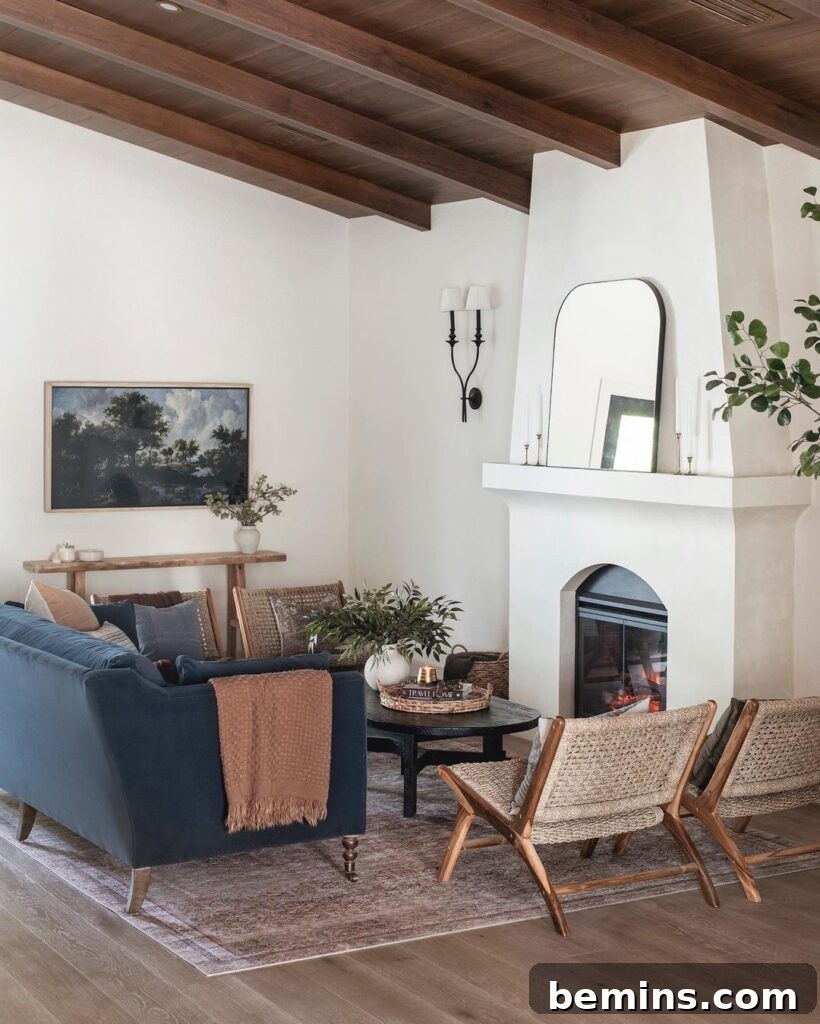 Living room with white stucco fireplace, blue couch, and earth-toned furniture creating a Spanish influence