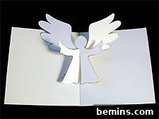 A delicate white angel pop-up card, crafted with intricate detail, suitable for holiday greetings.