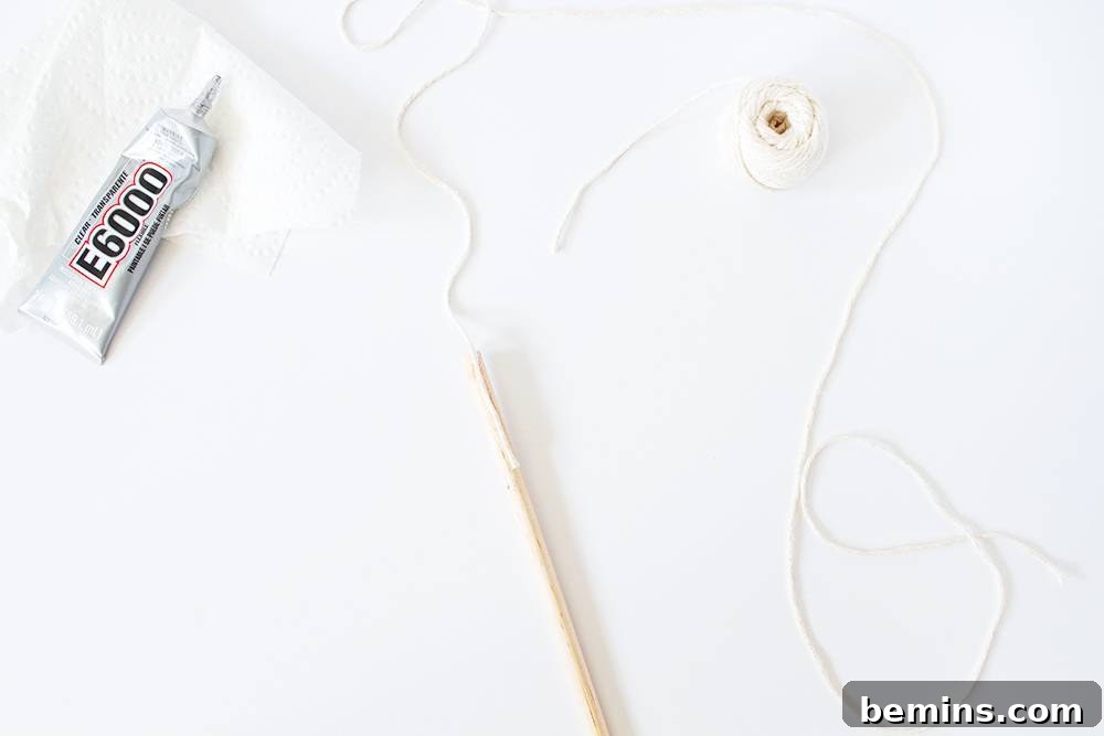Attaching the cotton string to the dowel, showing the glue being applied and the string being carefully secured.