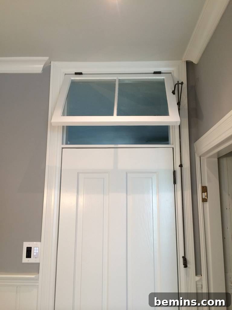 Transom Windows: A Complete Guide 8 White transom window over entryway door with black brackets to help hold it open