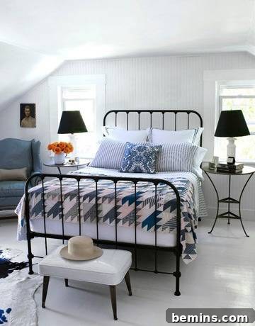 A traditionally styled bedroom with a blue and white color palette and an iron bed.