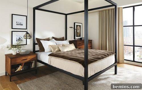 An iron bed in a room with a full-length window.