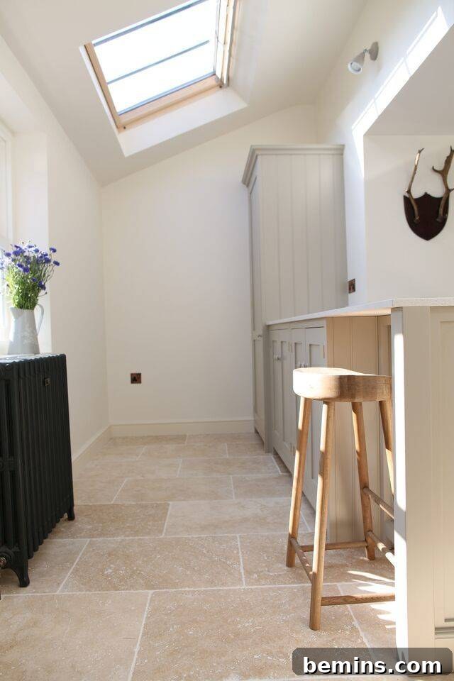 Elegant kitchen with beige travertine tile flooring and a matching kitchen island.