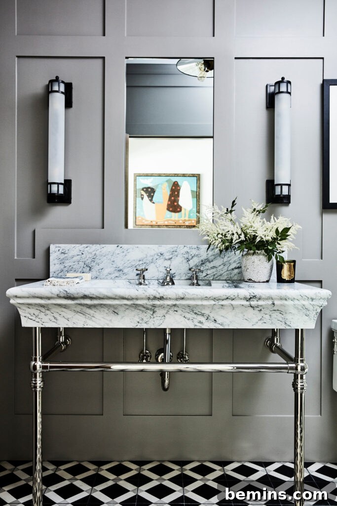 Gray bathroom with large marble sink and silver exposed metal underneath