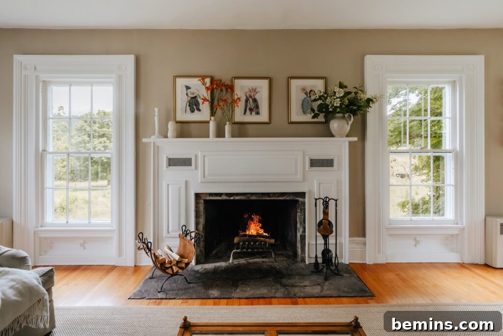 A cozy living room furnished with comfortable seating and a fireplace, featuring a firewood basket.