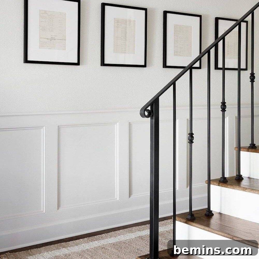 Inspiring Wainscoting: 15+ Dining Room Design Ideas 21 White flat panel wainscoting in hallway with brown stairs and four brown trimmed photos hanging on wall.