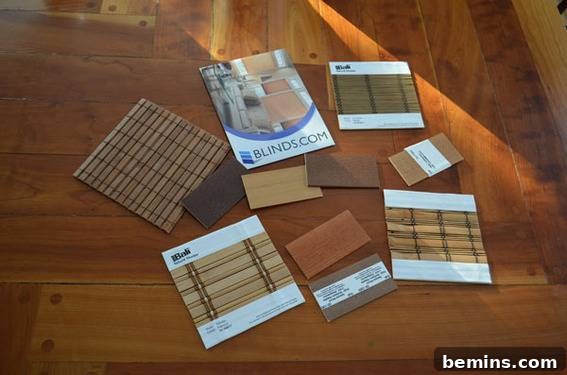 An array of window covering swatches displayed on a wooden surface for color and material comparison