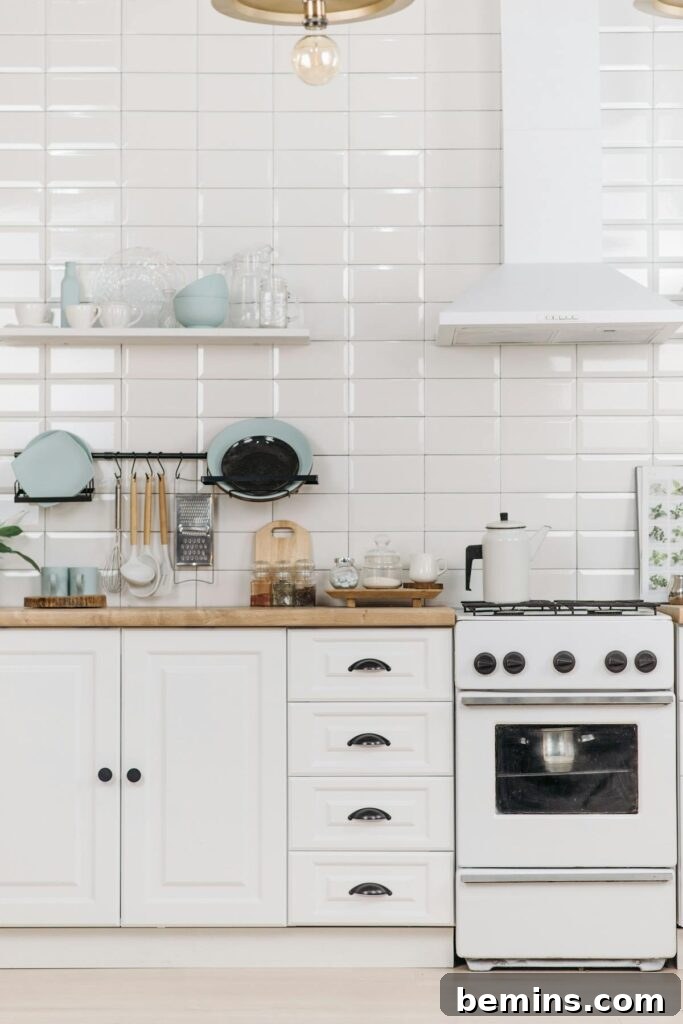 Modern kitchen interior with white cabinets and a stove, embodying a minimalist design.