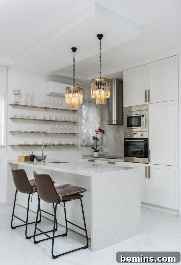 Sleek modern kitchen interior with white cabinets and elegant pendant lights.
