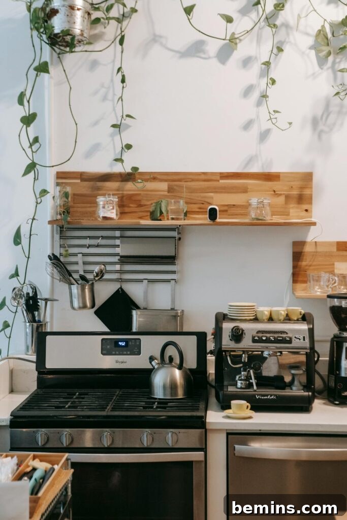 Interior of a contemporary light kitchen with modern appliances and a stove.