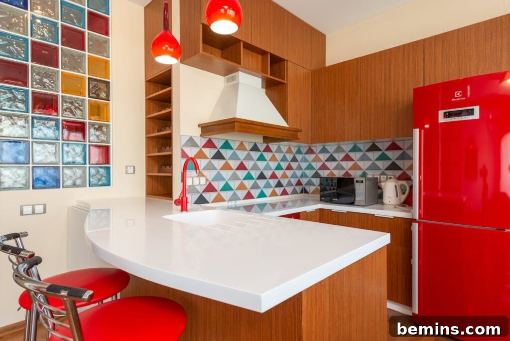 Interior of an empty stylish kitchen with a red fridge and colorful walls.
