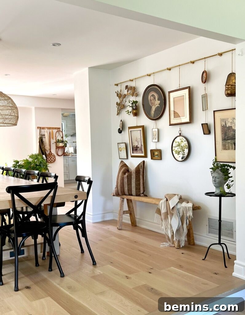 Command Strips Unleashed: Gallery Walls Without the Nail Holes 19 Wall in dining room with hanging pictures on rail, illustrating an alternative for displaying art collections without wall damage.