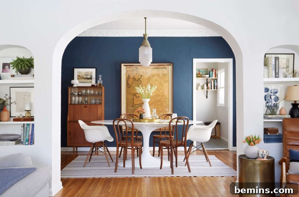 White dining room table with white armed chairs and four brown armless chairs