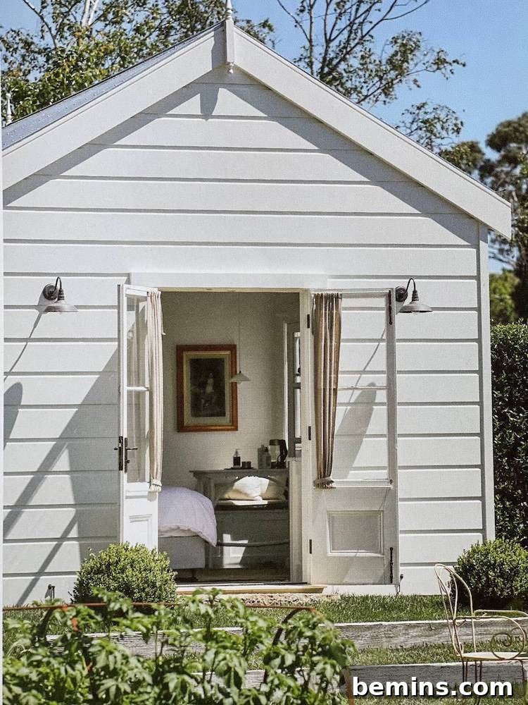 White shed with bed inside and table