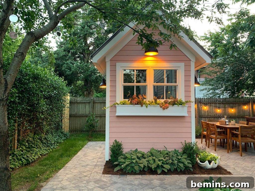 Pink shed with white window box holding colorful flowers