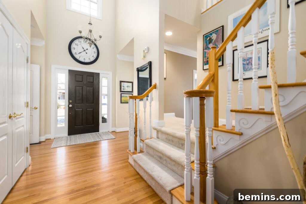 Elevate Your Entryway: Stunning Foyer Design Inspirations 13 A bright and spacious modern entrance hall featuring a large clock and elegant staircase.