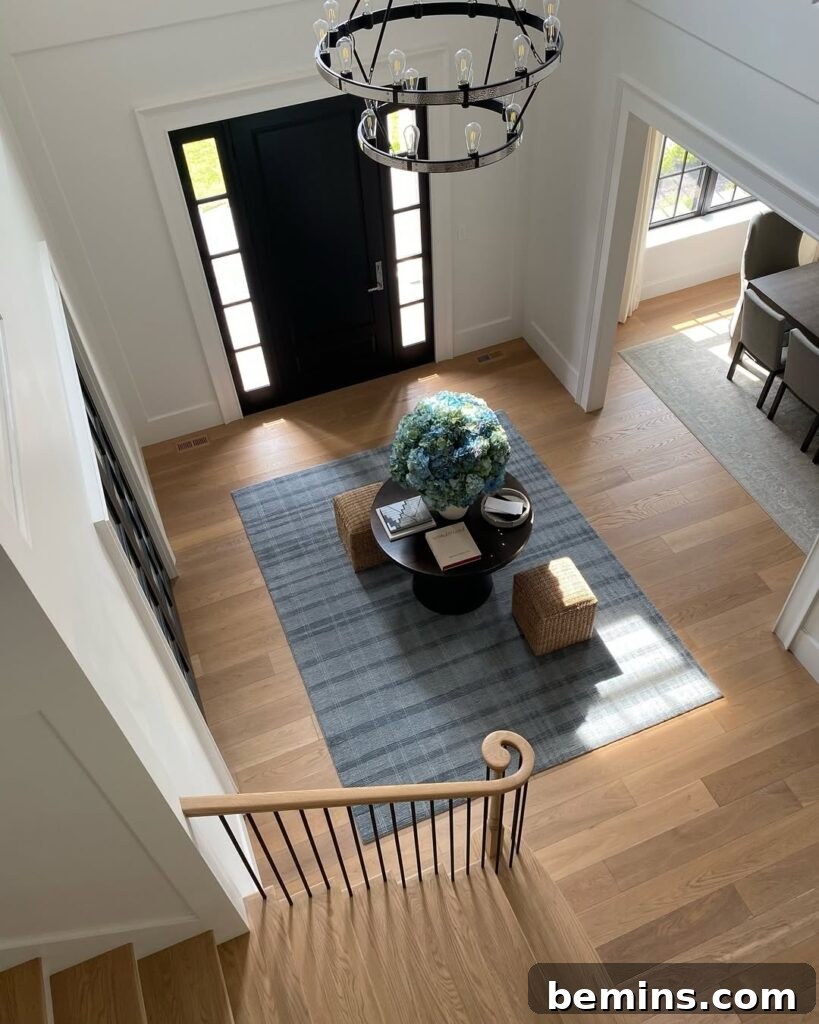 Elevate Your Entryway: Stunning Foyer Design Inspirations 6 White interior foyer with grey rug and black table