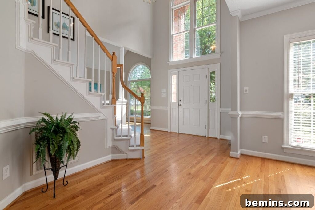 Elevate Your Entryway: Stunning Foyer Design Inspirations 9 Elegant entrance with a wooden staircase and large windows, perfect for modern interiors.