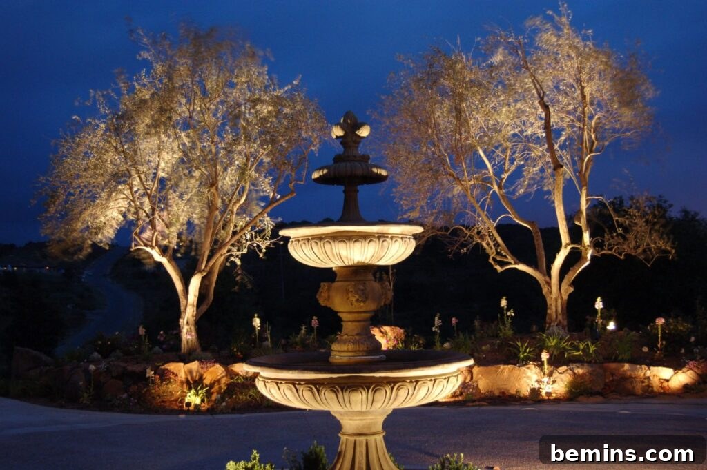Transform Your Garden with Brilliant Uplighting Designs 11 Water fountain surrounded by trees and illuminated by uplights