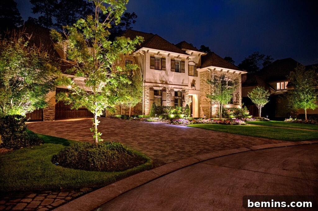 Transform Your Garden with Brilliant Uplighting Designs 13 Large white house with tree and a mixture of warm lighting from uplights and spotlights