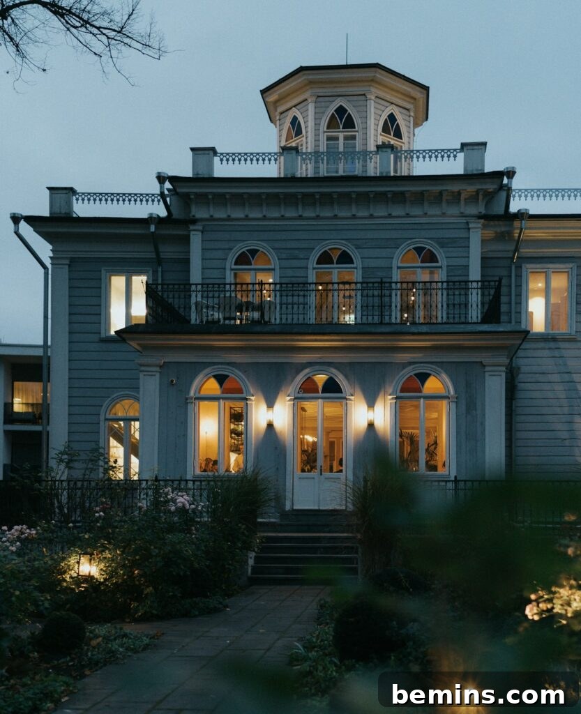 Transform Your Garden with Brilliant Uplighting Designs 17 A large house with a front porch well-lit by exterior lighting including uplights