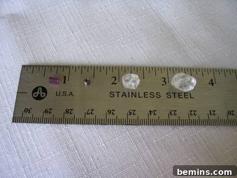 Different shapes and colors of beads placed on a stainless steel scale.