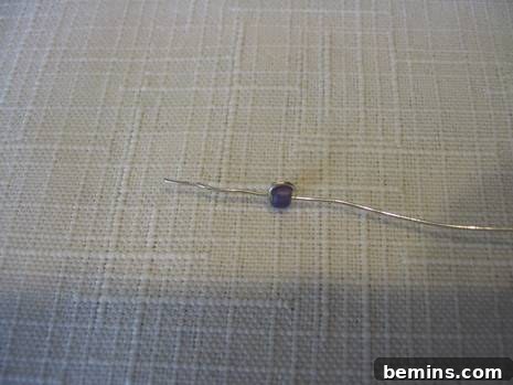 A silver wire is on the white carpet.