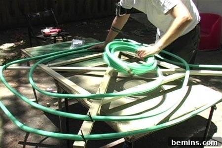 Garden hose spiraled on the wooden frame