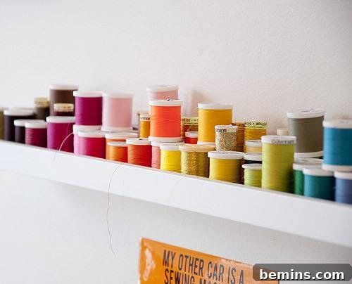 Reimagine Your Walls: 10 Upcycled DIY Art Projects 5 Various colored threads on a wall rack.
