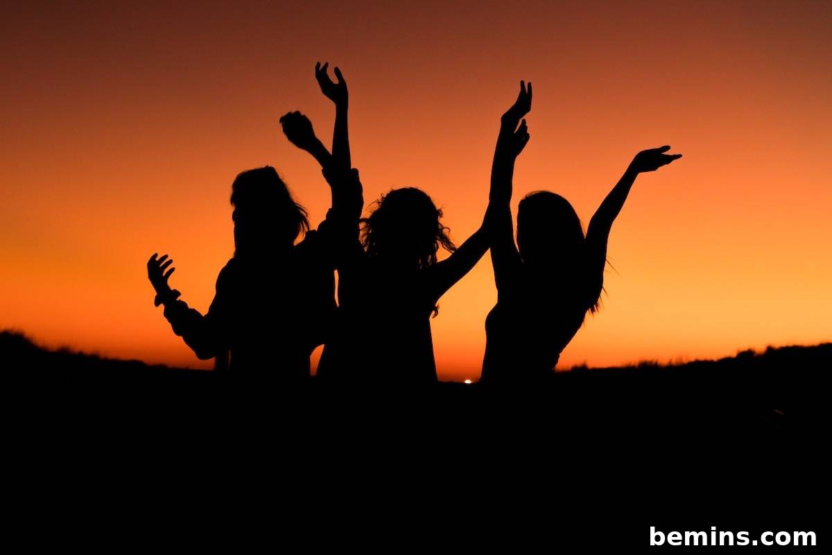 Hilarious Outdoor Games for Grown-Ups: Camping and Beyond 6 Three women dancing on the beach at sunset, enjoying a fun and lively beach party.