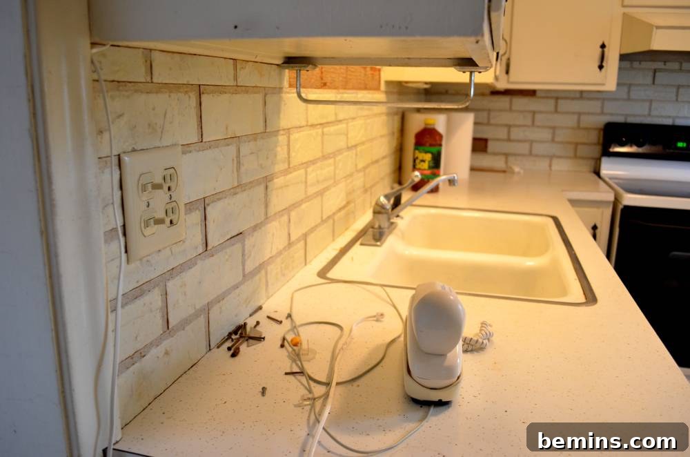 Subway tiles surround a white counter in a kitchen.