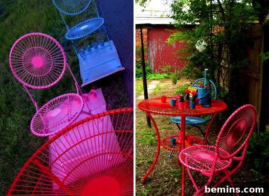 A pink chair outside near an orange table.