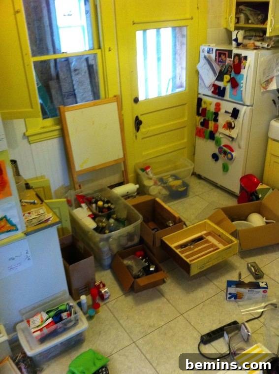 A kitchen floor covered with boxes of packed items.