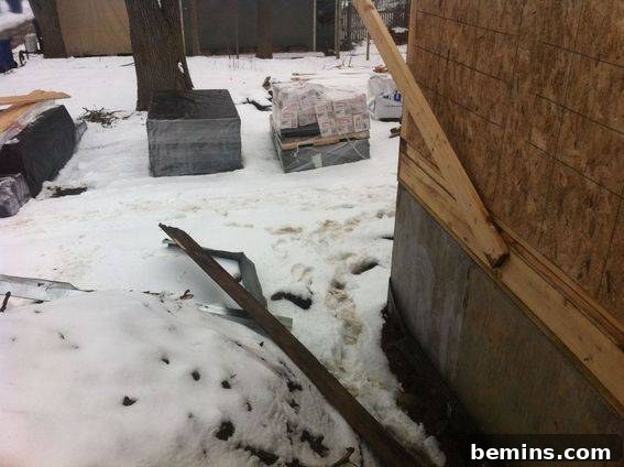 Snow covering the ground near a building under construction.