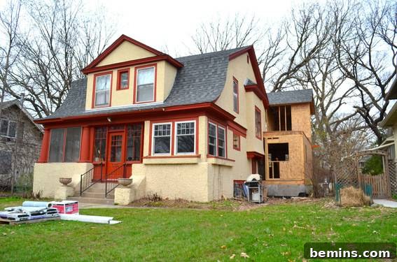 A two-story house with a new roof and bare trees in the yard.