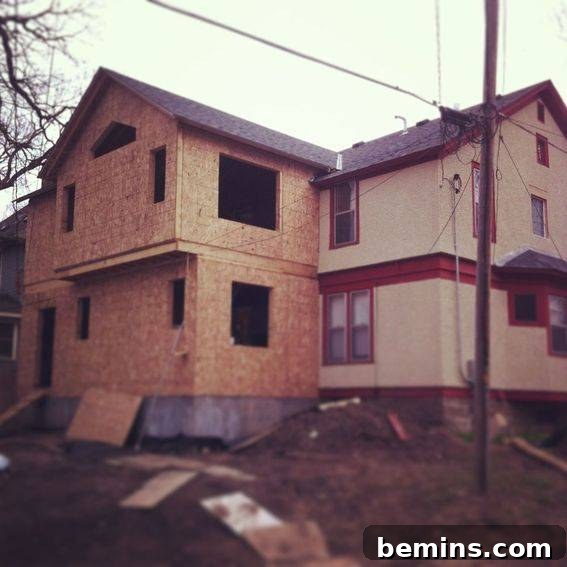 A partially constructed addition on the side of a house.