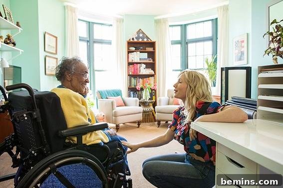 A young woman conversing with an elderly woman in a wheelchair, highlighting the importance of personalized care and attention in senior living environments.