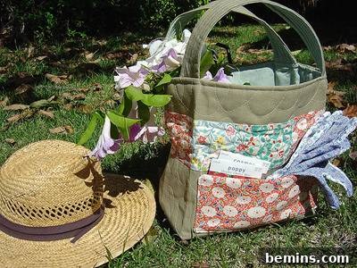 A straw hat and a cloth handbag sitting on the grass outside