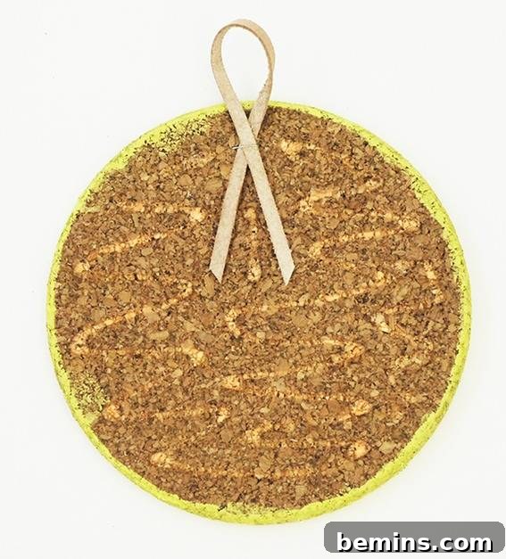 A round cork has a pink ribbon on it.