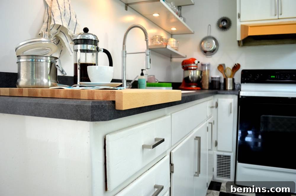 After: The transformed kitchen with new hardware on the white cabinets.