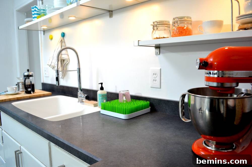 Close-up: The sleek, dark grey Wilsonart countertop with a sink and kitchen utensils.