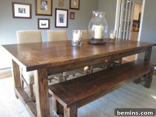 A rustic farmhouse dining table with a weathered look, surrounded by chairs and a bench.