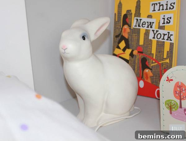 A white rabbit night light sits on a shelf.