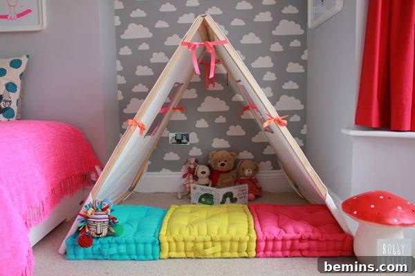 A kid's bedroom has a small open fort with cushions.