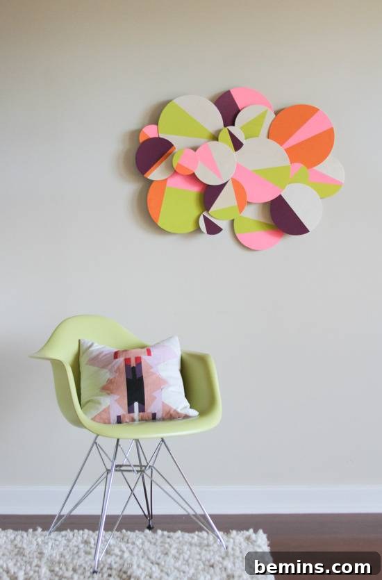 A beautifully decorated living room featuring a green chair, a white and pink pillow, and the finished dimensional circle wall art hanging above.