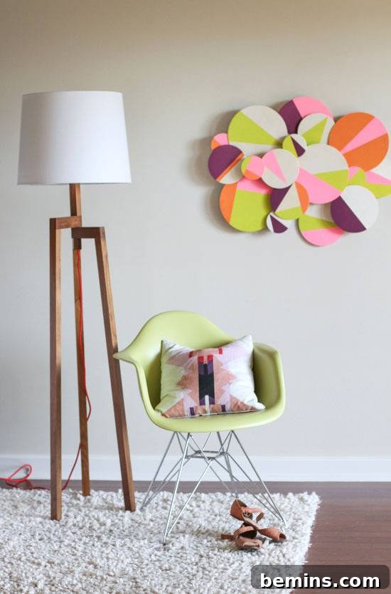 A stylish living room with a green chair, a floor lamp, a white rug, and the vibrant dimensional circle wall art as the focal point.